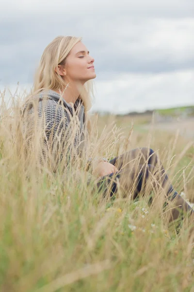Vista lateral da mulher pensativa bonito sentado na praia — Fotografia de Stock