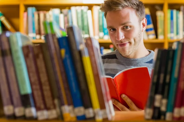 Άνδρας των φοιτητών που επιλέξετε το βιβλίο στη βιβλιοθήκη — Φωτογραφία Αρχείου