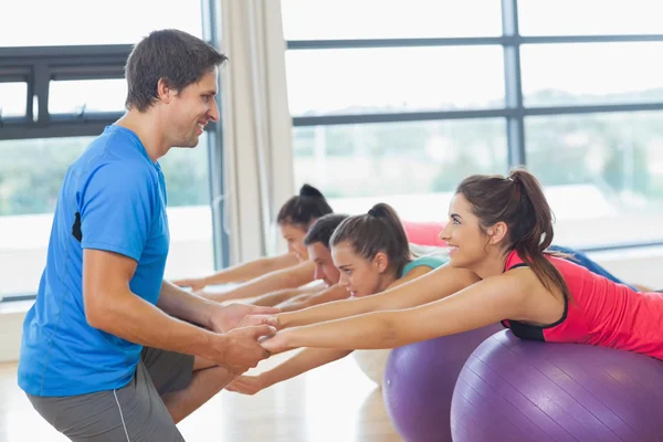 Entraîneur aidant femme au studio de fitness — Photo