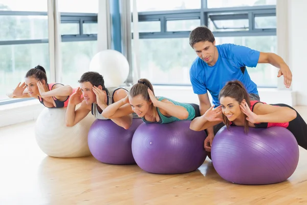 Trainer helping woman at fitness studio — Stock Photo, Image