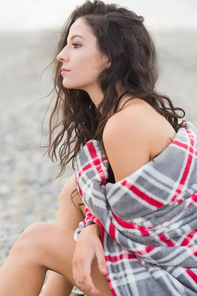 Mujer seria cubierta con manta en la playa — Foto de Stock