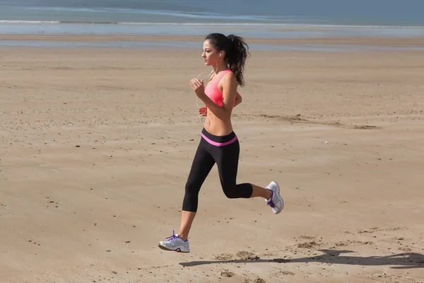 Volle Länge der gesunden Frau joggen am Strand — Stockfoto