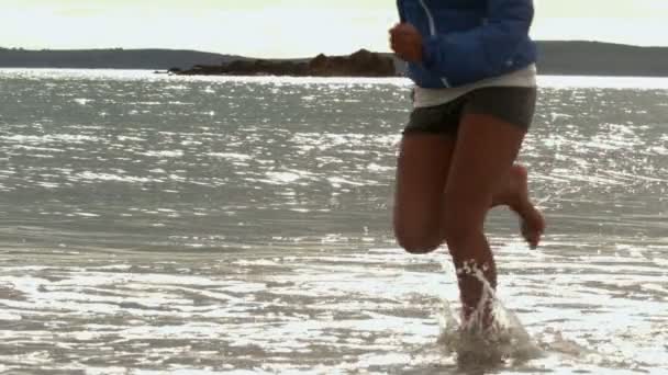 Piernas femeninas corriendo en la playa — Vídeo de stock