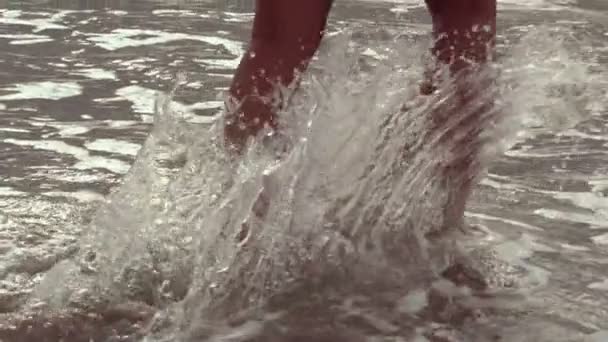 Женские ноги прогуливаются по пляжу — стоковое видео