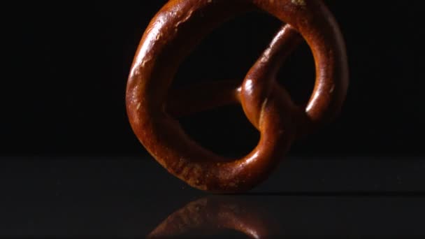 Pretzel girando sobre la superficie negra — Vídeo de stock