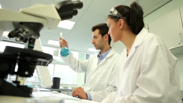 Estudantes de química olhando para química azul — Vídeo de Stock