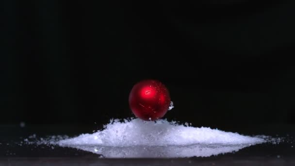 Vánoční cetka dopadající na hromádku třpytky na bílém pozadí — Stock video
