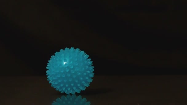 Massage ball rolling across black surface — Stock Video