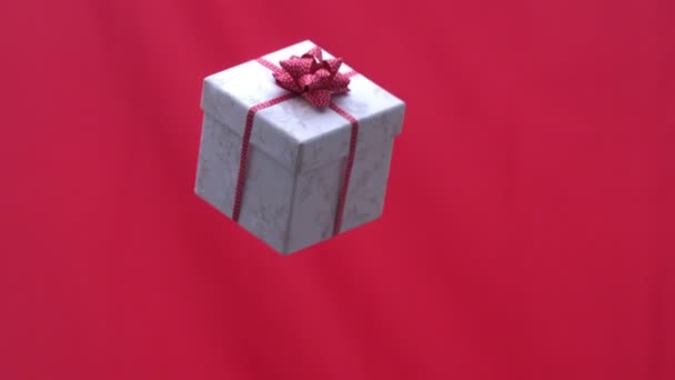 赤の背景に空気に投げられるクリスマス プレゼント — ストック動画