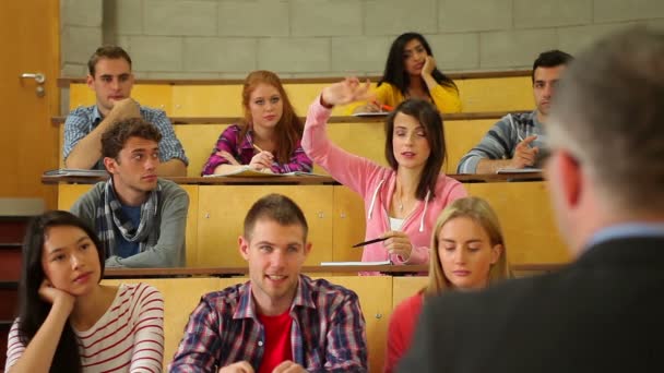 Student raising her hand to ask question in lecture — Stock Video