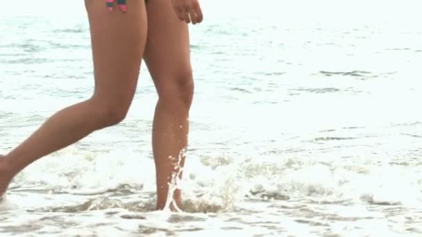 Piernas femeninas caminando en el agua — Vídeo de stock