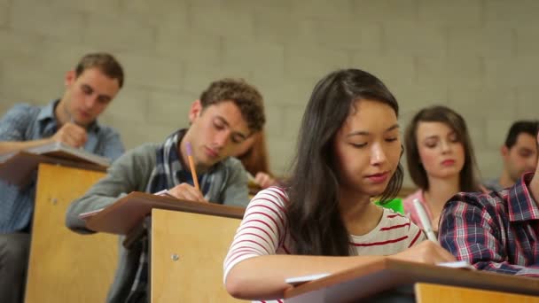 Estudiantes escuchando atentamente en la sala de conferencias y tomando notas — Vídeo de stock