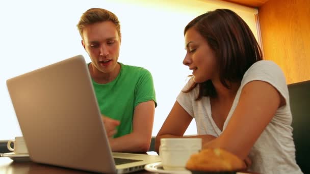 Friends chatting in the canteen over coffee using laptop — Stock Video