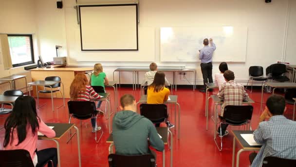 Dozent schreibt im Unterricht auf dem Whiteboard — Stockvideo