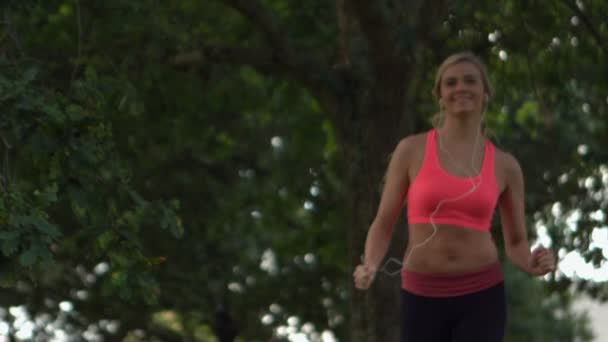 Glücklich durchtrainierte Blondine läuft im Park — Stockvideo