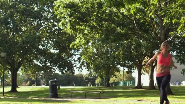 Feliz tonificado rubia saltando en el aire en el parque — Vídeo de stock