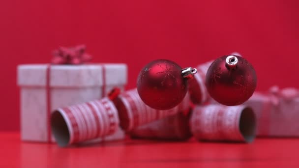 Boże Narodzenie bombki spada i odbijając się obok krakersy i prezenty — Wideo stockowe