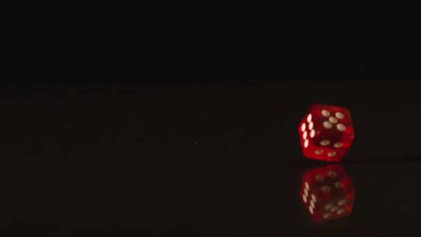Red plastic dice spinning on black background — Stock Video