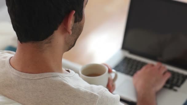 Man drinking coffee while using laptop — Stock Video