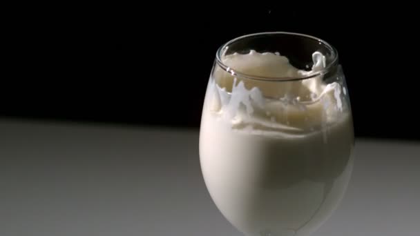 Aardbei vallen in glas melk — Stockvideo