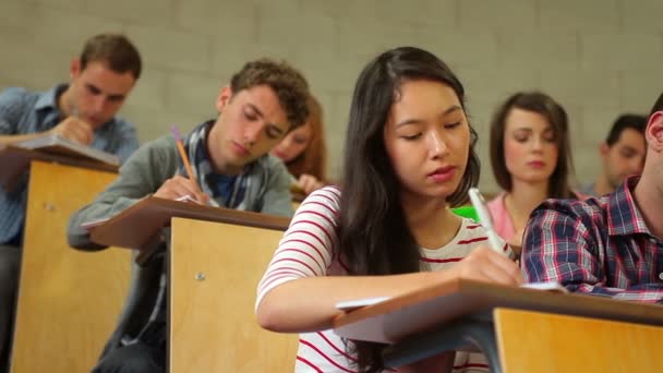 Studenten luisteren in collegezaal en maken van aantekeningen — Stockvideo