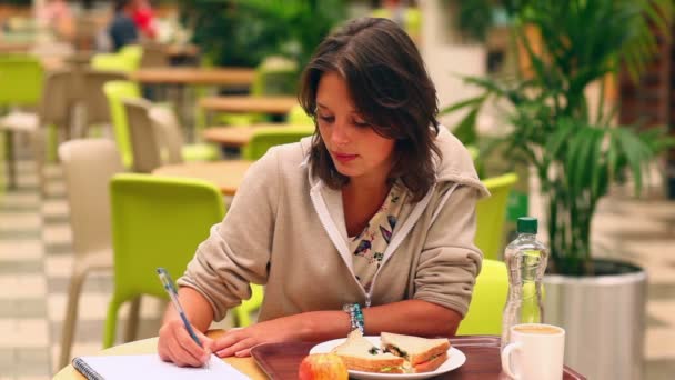 Jolie étudiante étudiant tout en déjeunant en cantine — Video