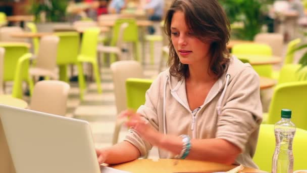 Happy student studying and drinking water in canteen — Stockvideo