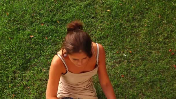 Student ležel na trávníku a s úsměvem — Stock video