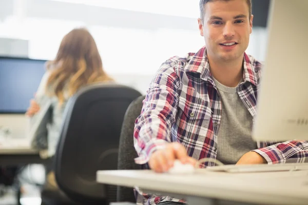 Glada student tittar på kameran i datasalen — Stockfoto