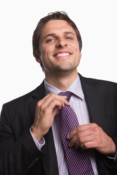 Retrato de un feliz hombre de negocios ajustando corbata — Foto de Stock