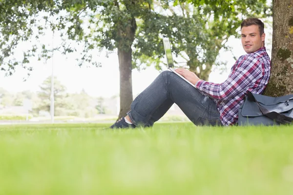 Glad student med sin laptop för att studera utanför — Stockfoto