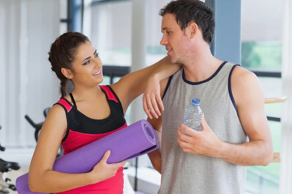 Couple avec bouteille d'eau et tapis d'exercice dans la salle d'exercice — Photo