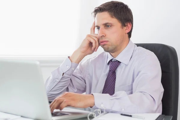 Besorgter Geschäftsmann mit Laptop im Büro — Stockfoto