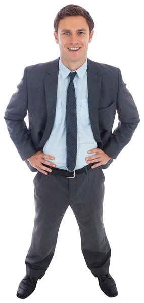 Cheerful businessman standing with hands on hips — Stock Photo, Image