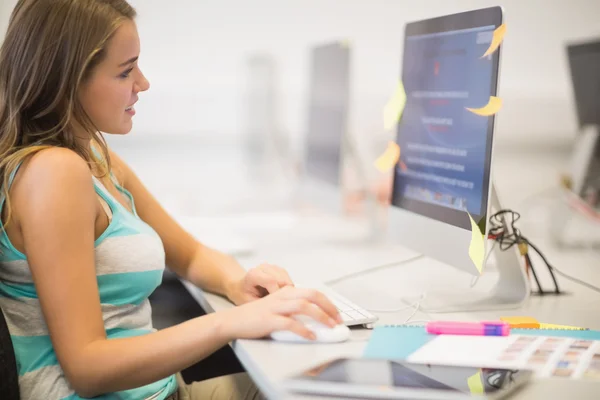 Glückliche junge Studentin arbeitet im Computerraum — Stockfoto