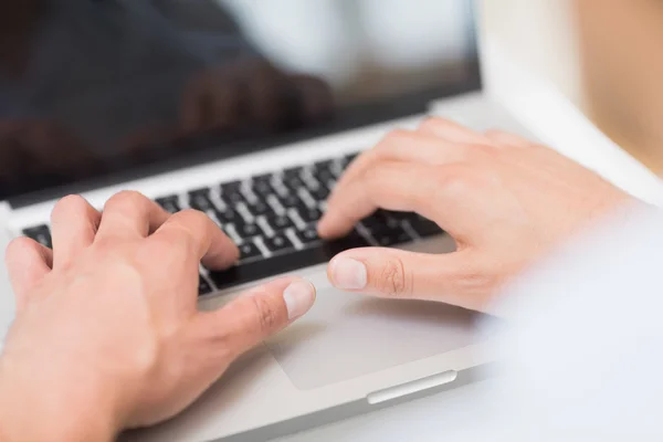 Manos usando el teclado borroso portátil — Foto de Stock