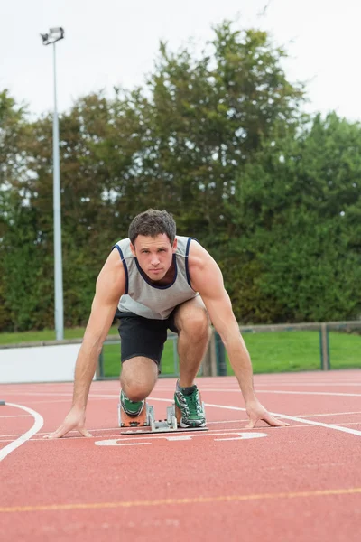 Young man ready to race on running track — Stock Photo, Image