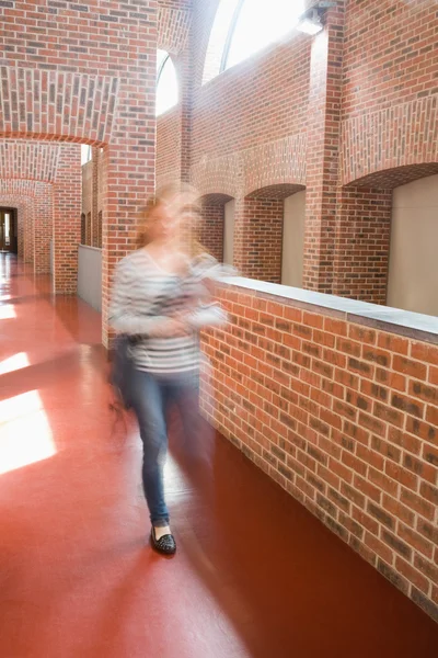 Giovane studente che corre nella sala tenendo cartelle — Foto Stock