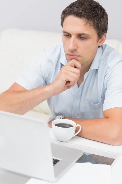 Vista lateral de um homem sério usando laptop em casa — Fotografia de Stock