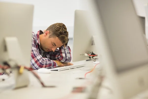 Estudiante guapo estresado estudiando en la sala de computadoras — Foto de Stock