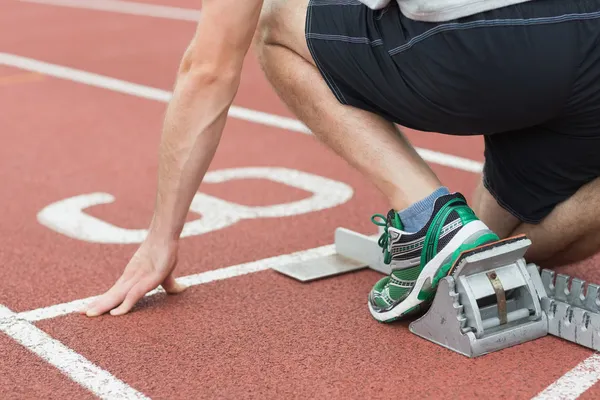 Niedriger Abschnitt eines Mannes bereit für das Rennen auf der Laufstrecke — Stockfoto