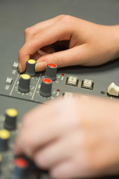 Mãos a trabalhar numa mesa de mistura de som — Fotografia de Stock