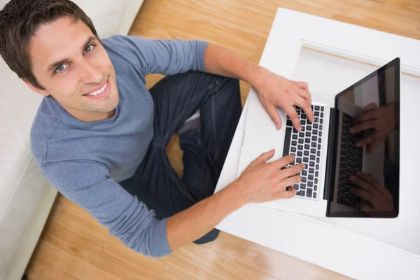 Накладний портрет чоловіка, який використовує ноутбук у вітальні — стокове фото