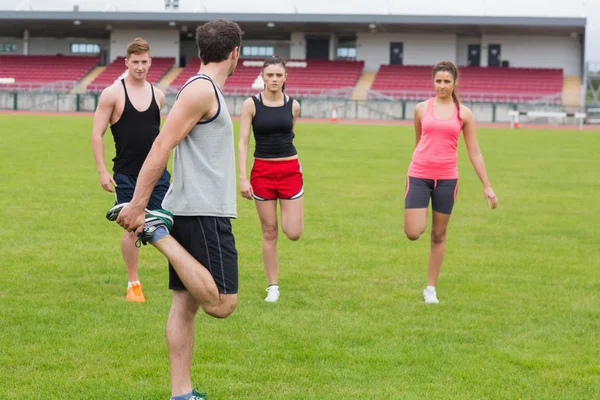 Young people doing stretching exercise at the park — Stock Photo, Image