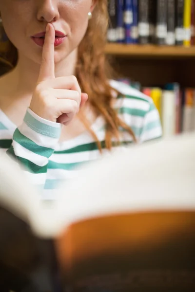 Uczeń prosi o ciszę, trzymając książkę — Zdjęcie stockowe