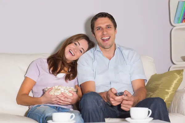 Casal feliz com vinho e pipocas desfrutando de um filme em casa — Fotografia de Stock