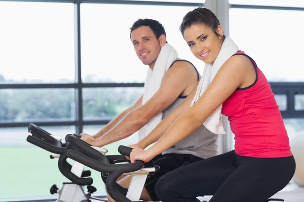 Joven hombre y mujer haciendo ejercicio en la clase de spinning —  Fotos de Stock