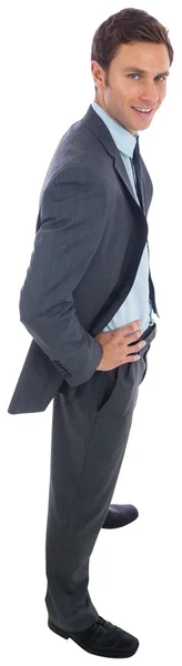 Cheerful businessman standing with hands on hips — Stock Photo, Image