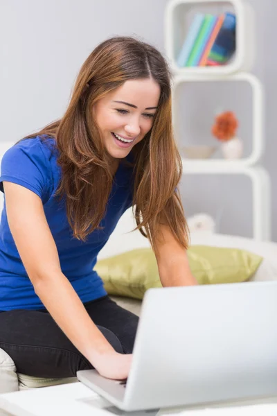 Evde dizüstü bilgisayar kullanan gülümseyen kadın. — Stok fotoğraf