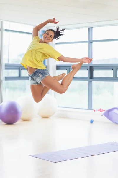 Jeune femme sautant dans un studio de fitness — Photo